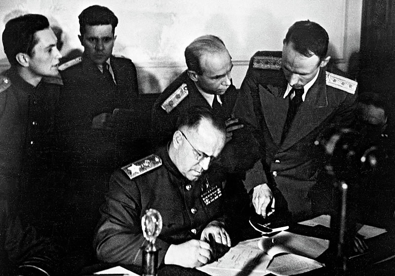 Маршал Советского Союза Г.К. Жуков ставит свою подпись под Актом о безоговорочной капитуляции Германии.