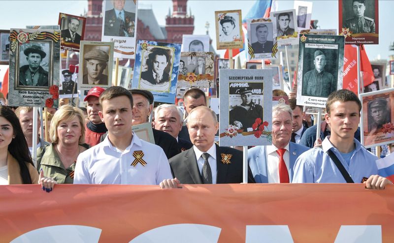 В День Победы Владимир Путин принимает участие в шествии &#171;Бессмертного полка&#187;. Глава государства идет по Красной площади, держа в руках портрет отца-фронтовика.
